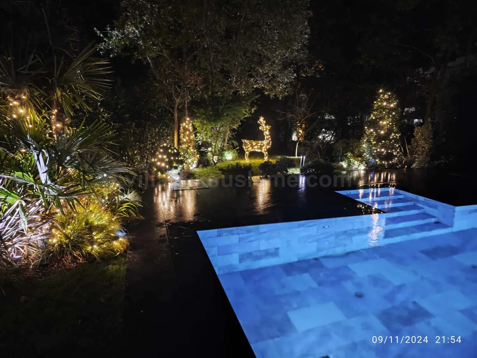 Villa bahçesinde havuz ve ahşap pergolada ışık