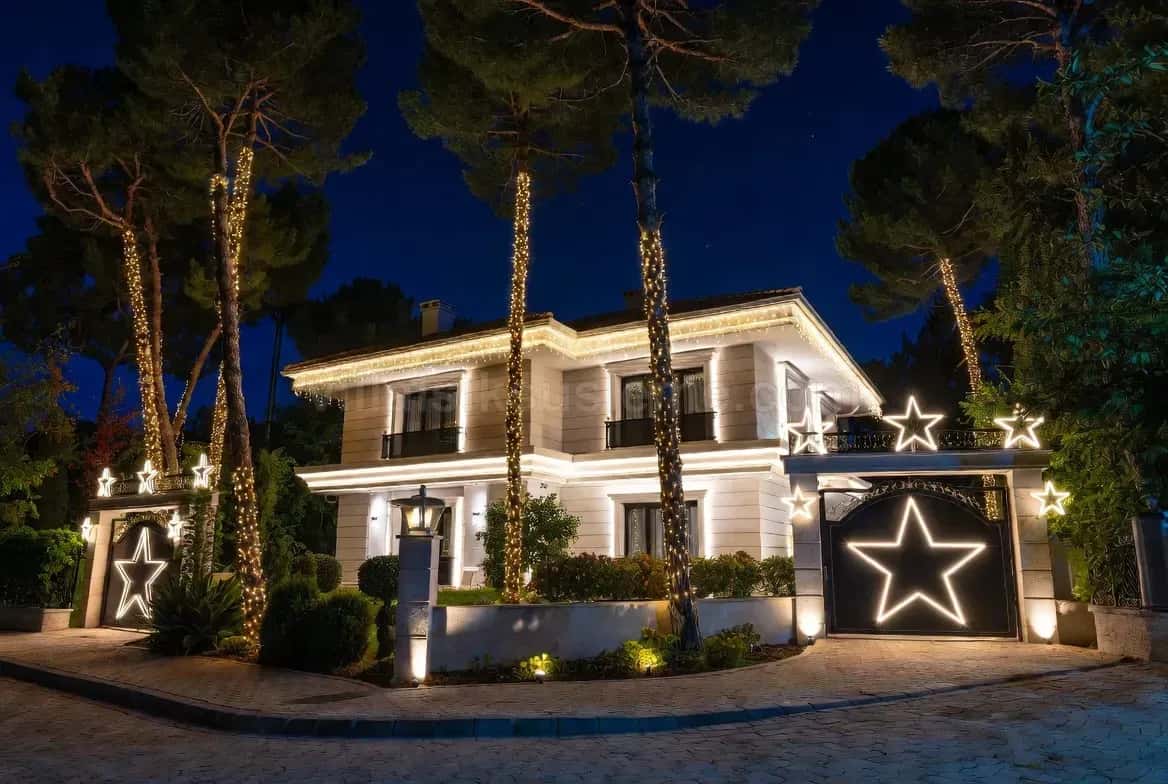 Modern villanın bahçe duvarında ışıklı yıldız motifleri